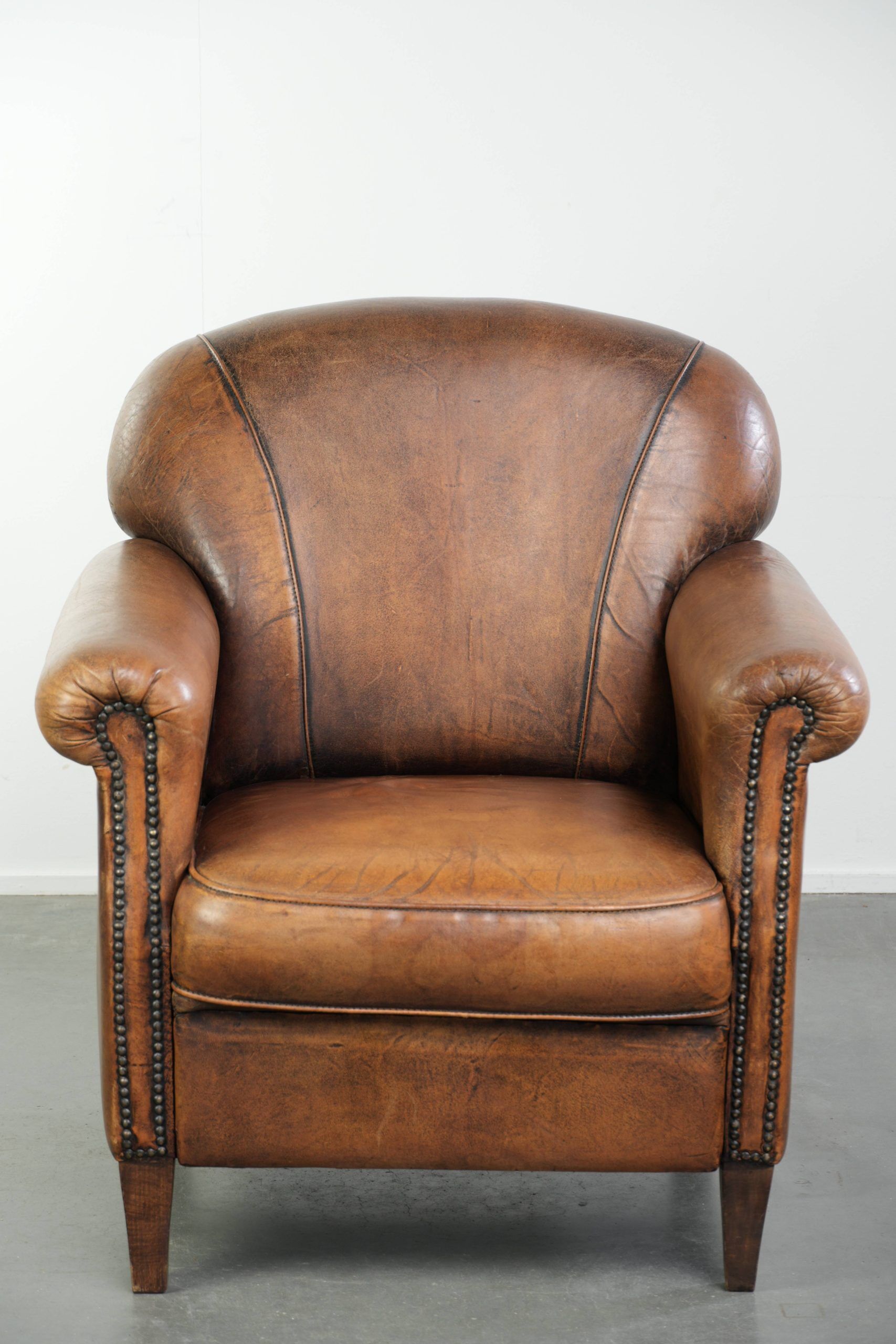 Comfortable characterful sheepskin armchair finished with decorative nails
