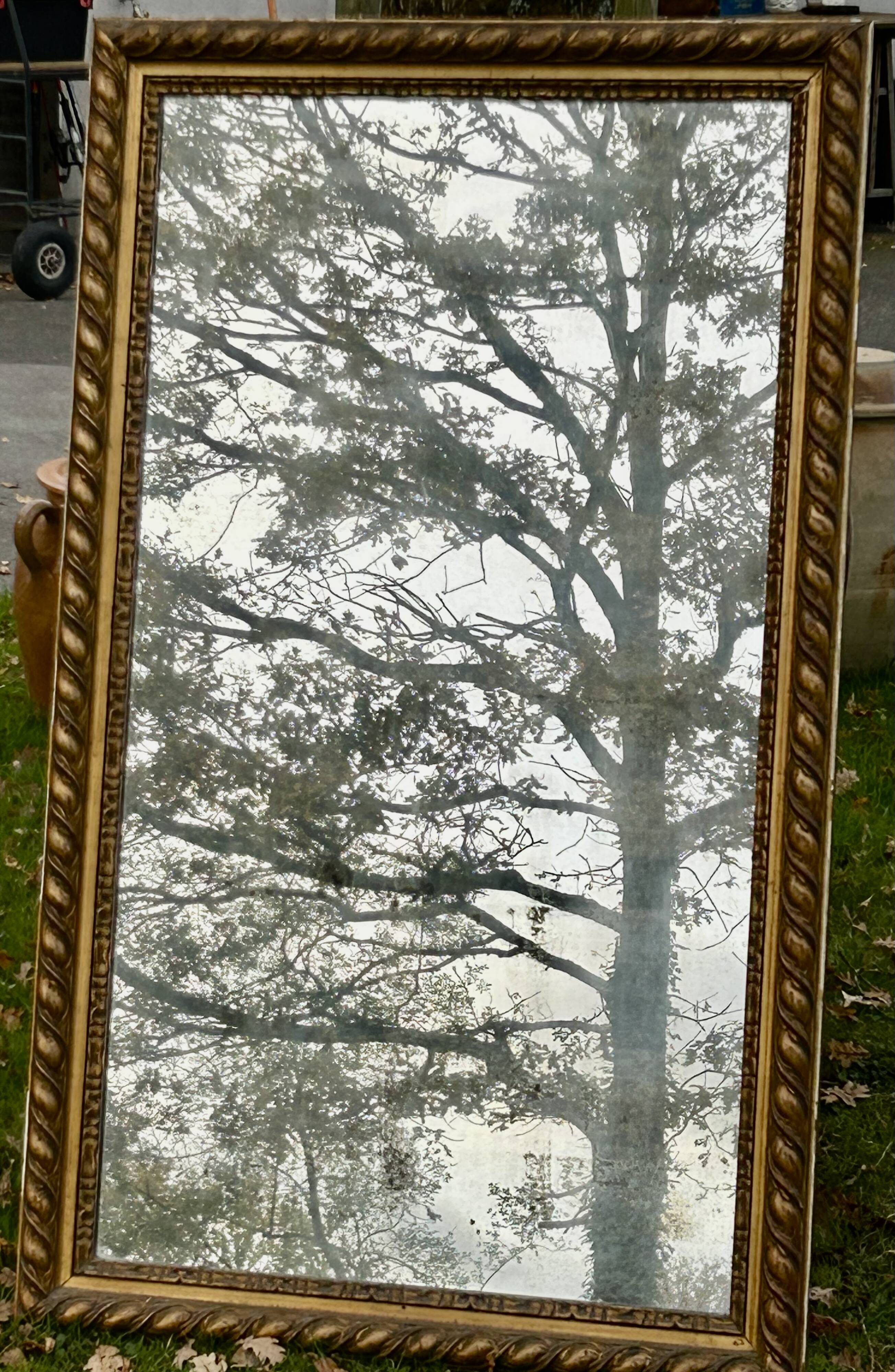 Large antique gilded mirror, wood and stucco gadroons, partially de-mercury