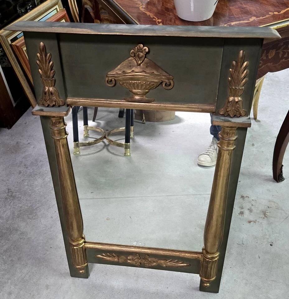 Empire-style mirror in deep green lacquered wood richly enhanced.