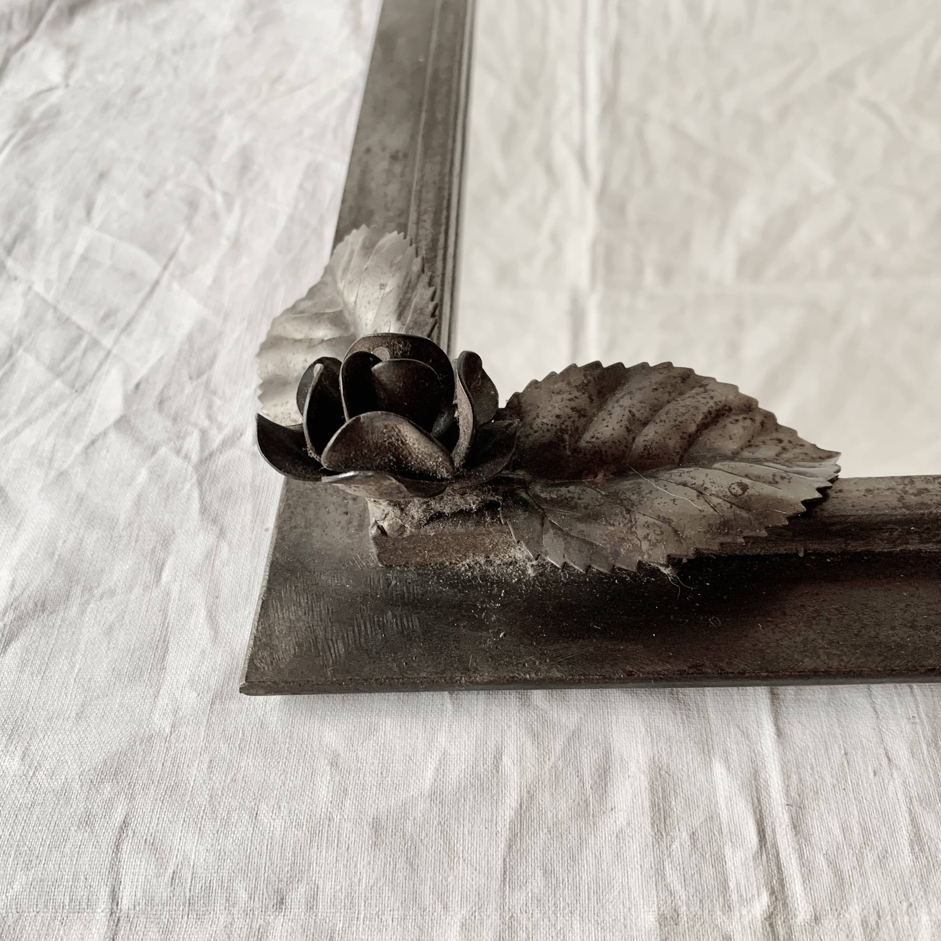 Vintage wall mirror in varnished steel decorated with a rose in relief