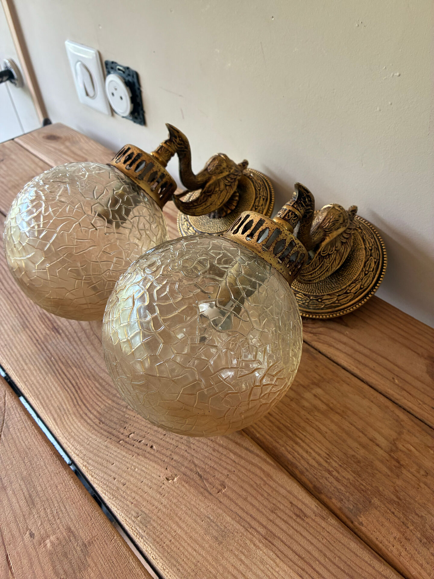 Pair of vintage wall sconces with golden metal swan heads and glass.