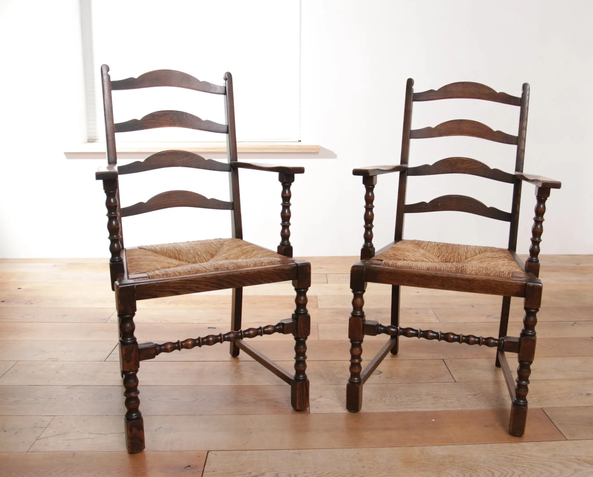 Pair of English oak armchairs with ladder back and rush seats