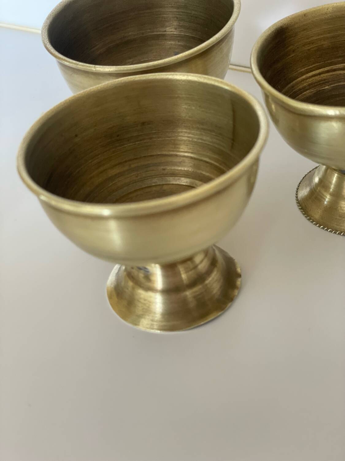 4 golden brass egg cups