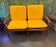 Vintage Scandinavian two-seater bench with mustard yellow cushions.