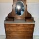 Antique carved wooden dressing table with marble and tilting oval mirror.