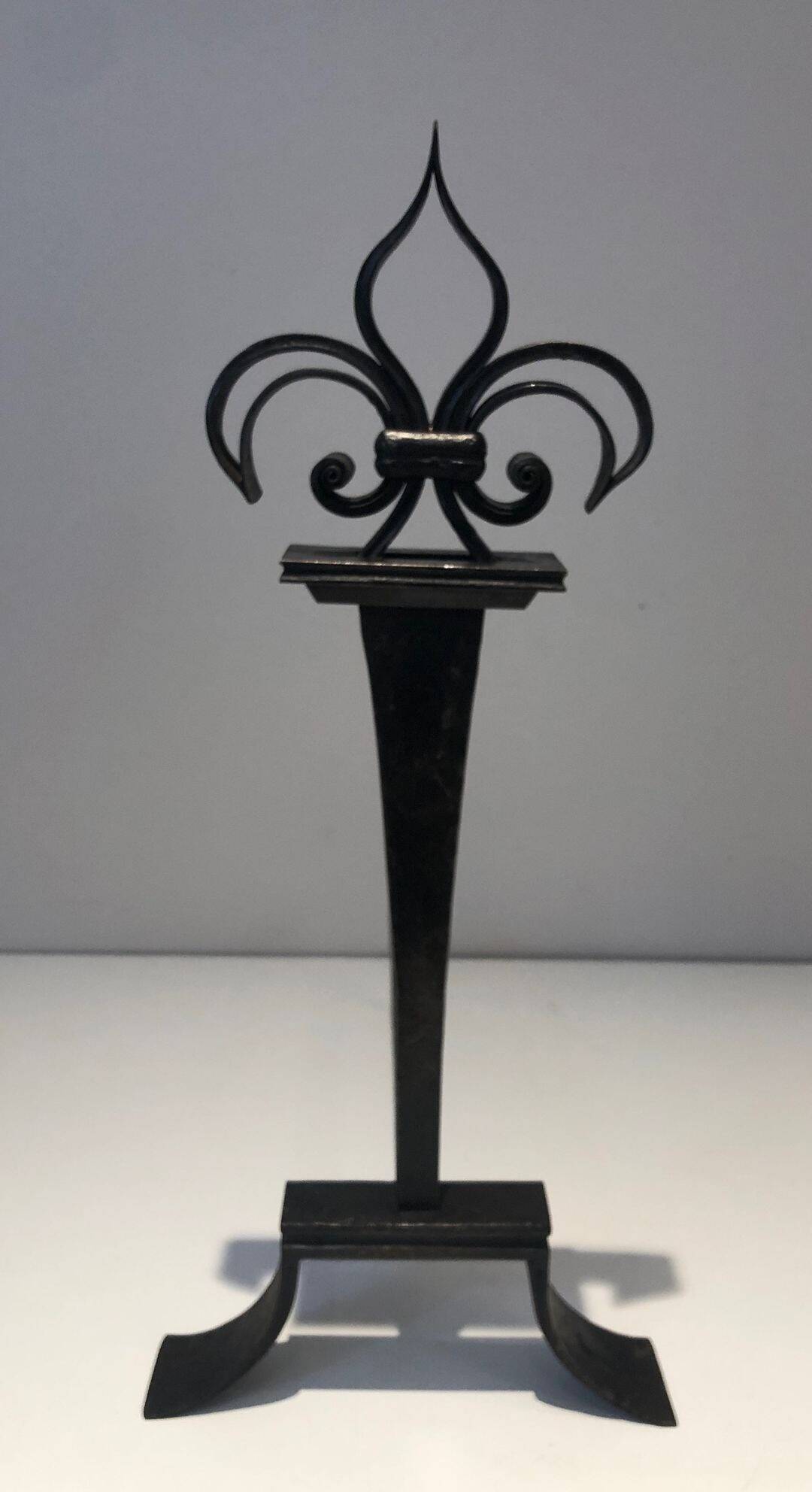 Important pair of wrought iron andirons with torch in heraldic fleur-de-lis design.