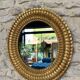 Pair of antique oval mirrors gilded with gold leaf and mercury.