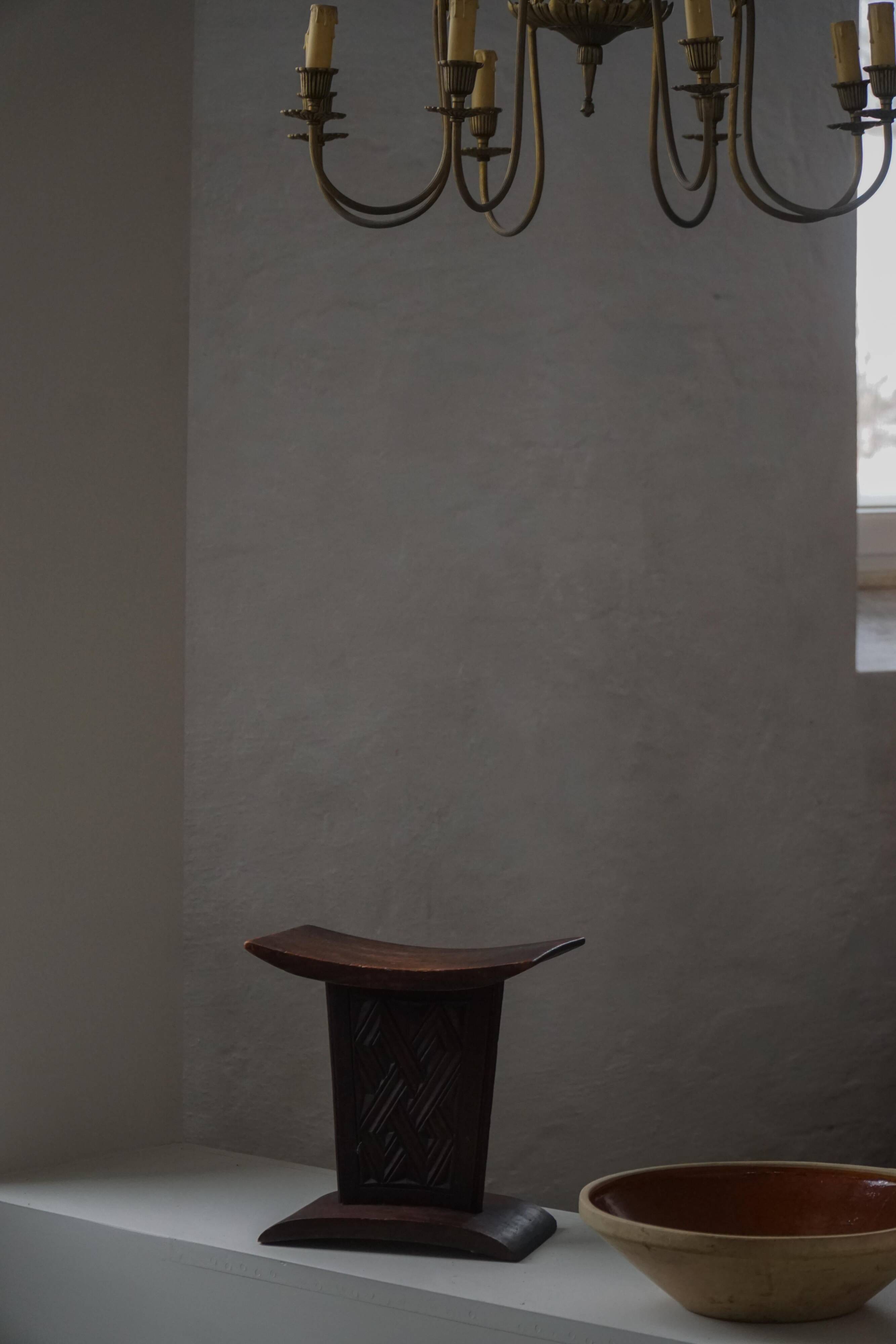 Sculptural African stool in hardwood, curved seat and architectural base, 1970s.