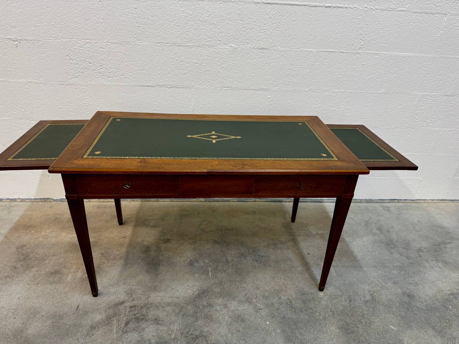 Louis XVI desk with green leather and shelves.