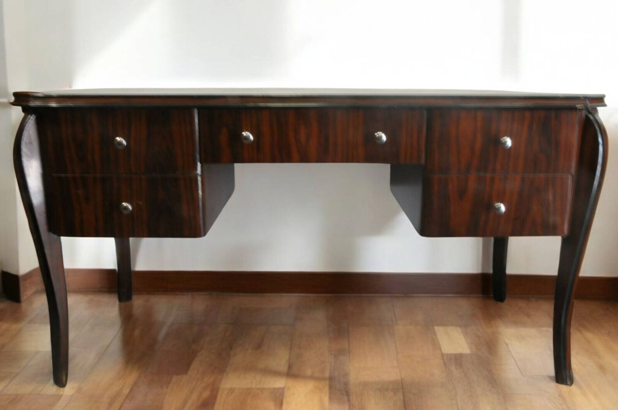 A large Art Deco style rosewood desk with 5 drawers and decorative motifs