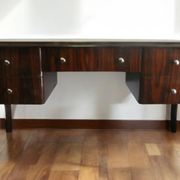 A large Art Deco style rosewood desk with 5 drawers and decorative motifs