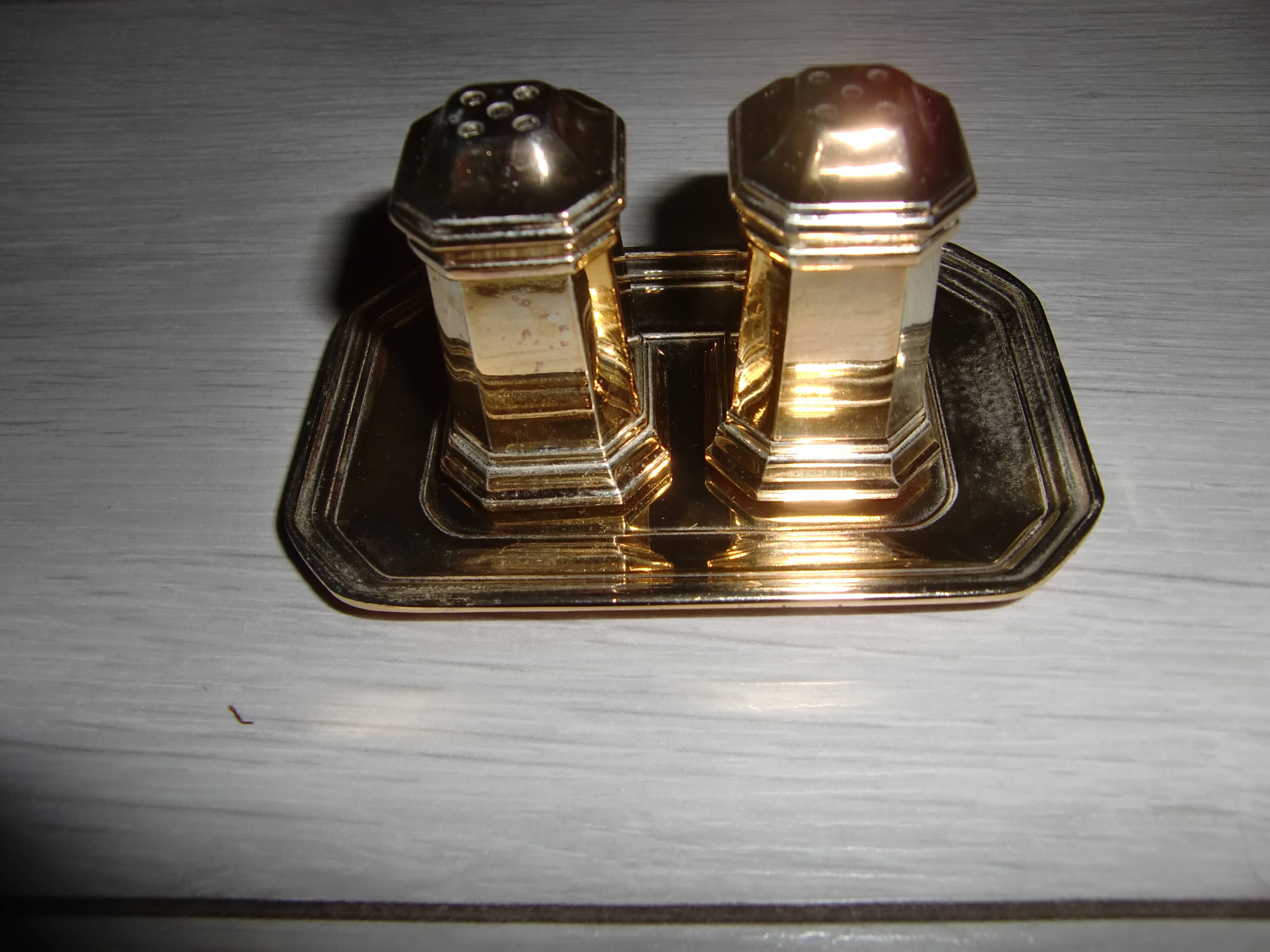 Silver-plated salt and pepper shakers presented on a small tray