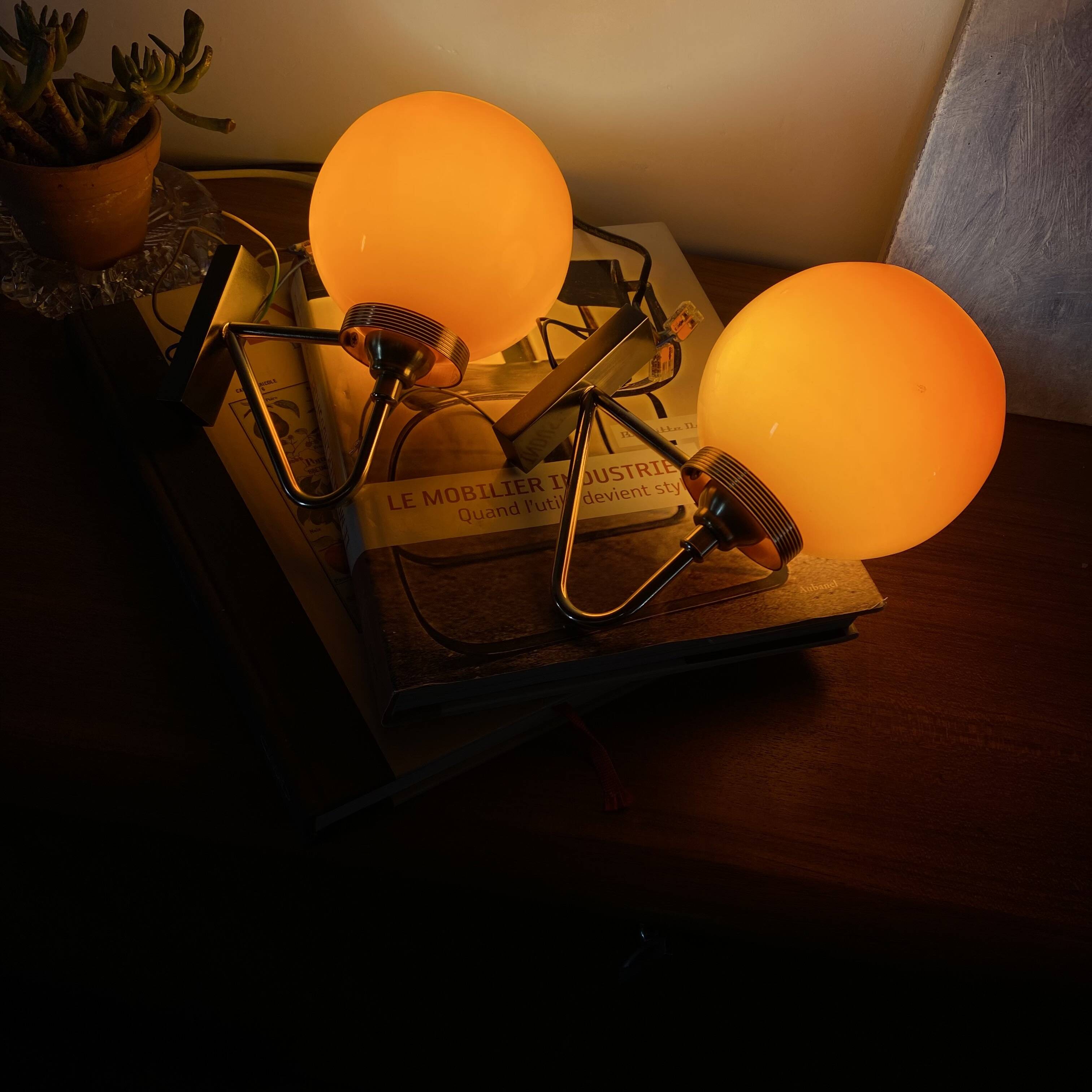 Pair of wall sconces with orange opaline globes and gold metal.