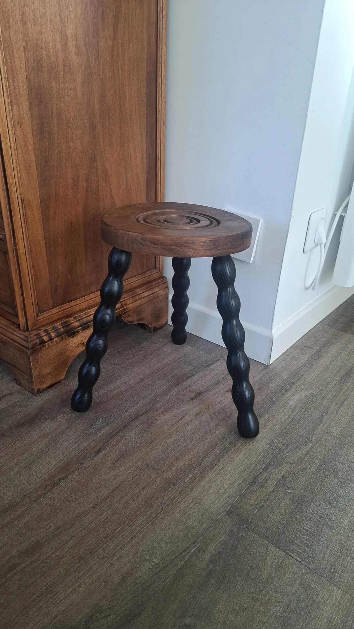 Brown and black wooden tripod stool