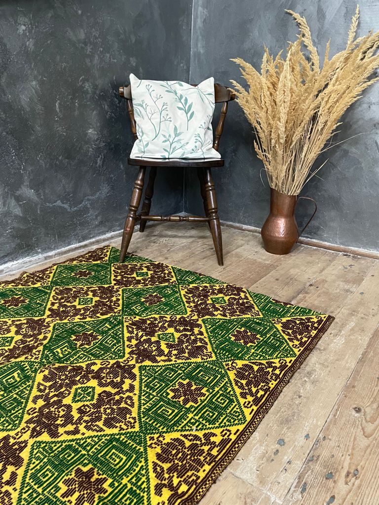 Green and yellow handmade rug with delicate colourful flowers