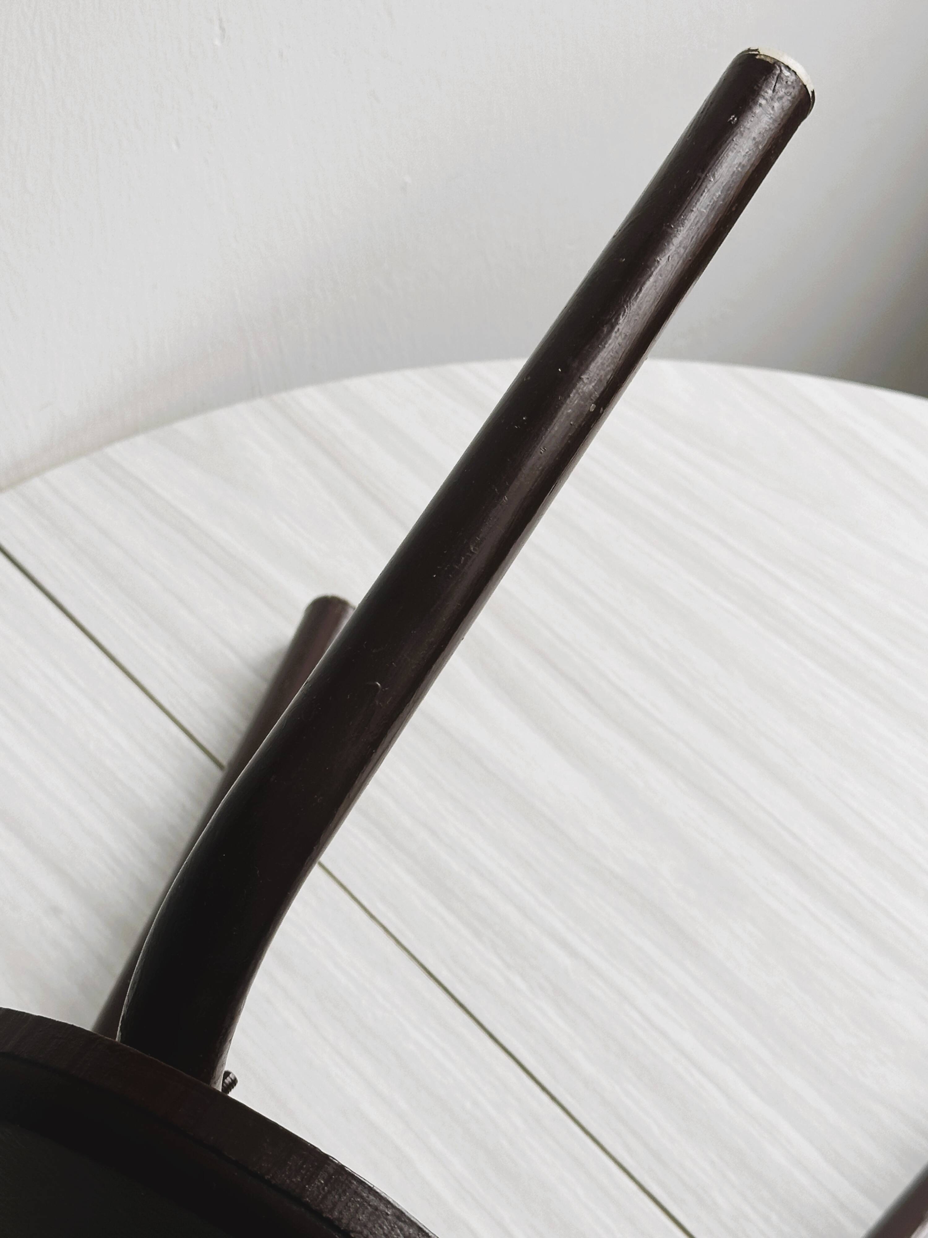 Dark brown metal stool, minimalist three-legged design