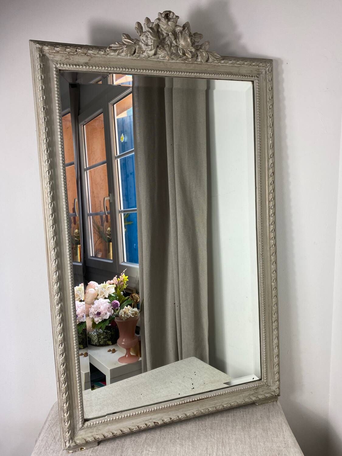 Large antique beveled mirror in carved wood painted with floral decoration and