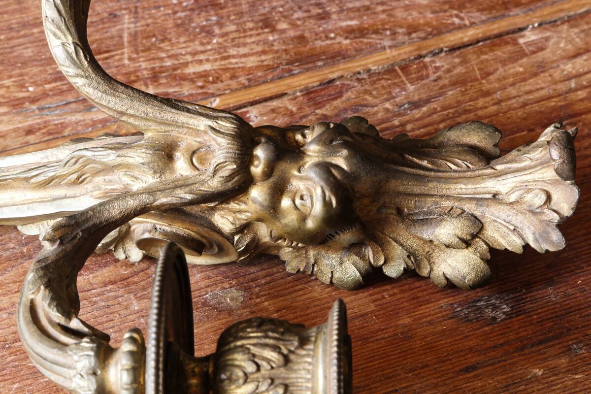 Monobloc gilded bronze wall light, grotesque satyr, two lights.