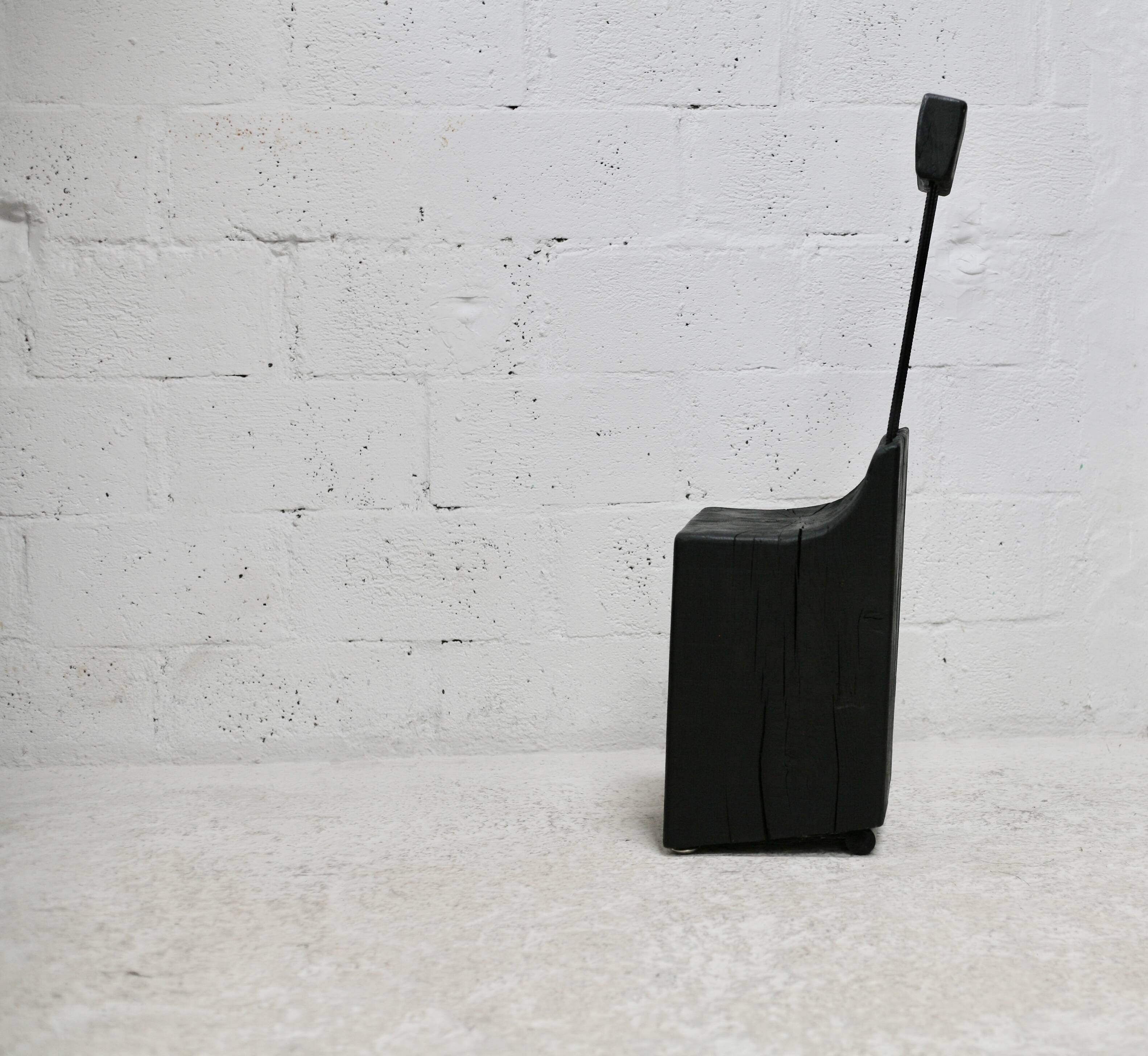 Brutalist chair, black-stained raw wood, steel. Work from the 1970s