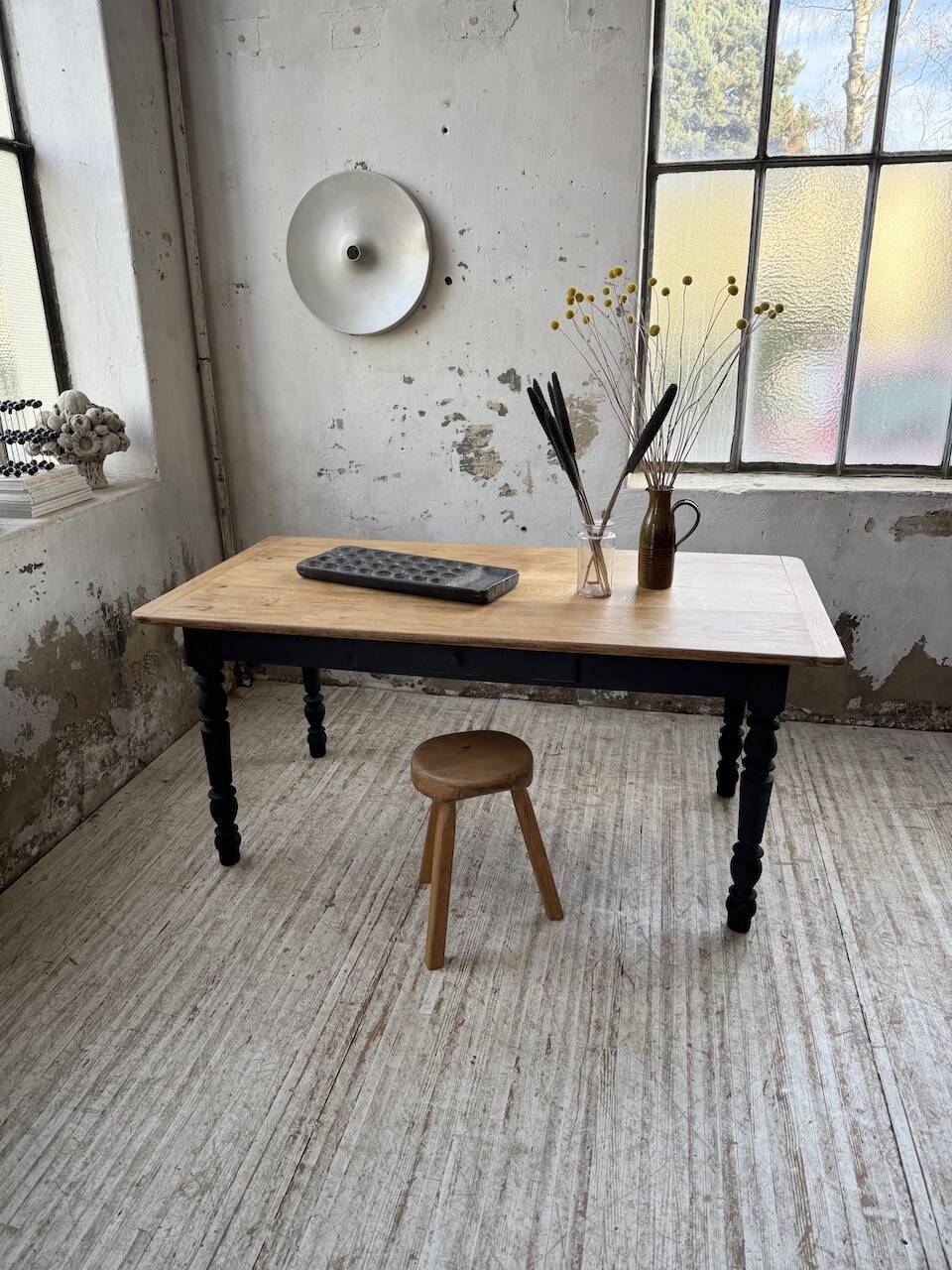 Oak farmhouse table with turned black legs.