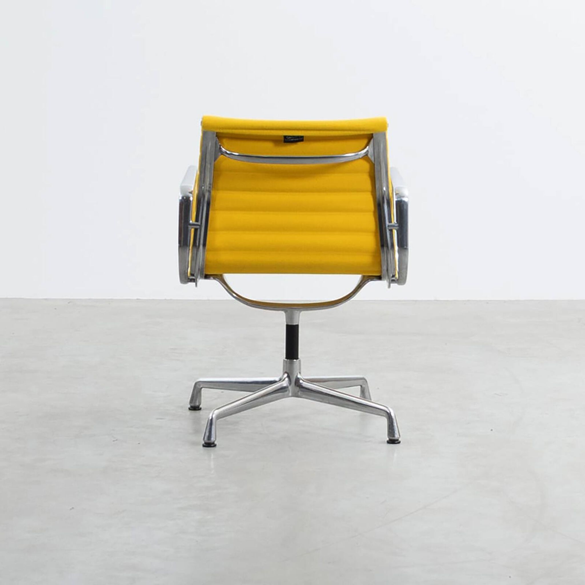 Fauteuil Aluminum Group EA107 de Charles et Ray Eames en tissu jaune.