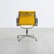 Fauteuil Aluminum Group EA107 de Charles et Ray Eames en tissu jaune.