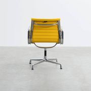 Fauteuil Aluminum Group EA107 de Charles et Ray Eames en tissu jaune.