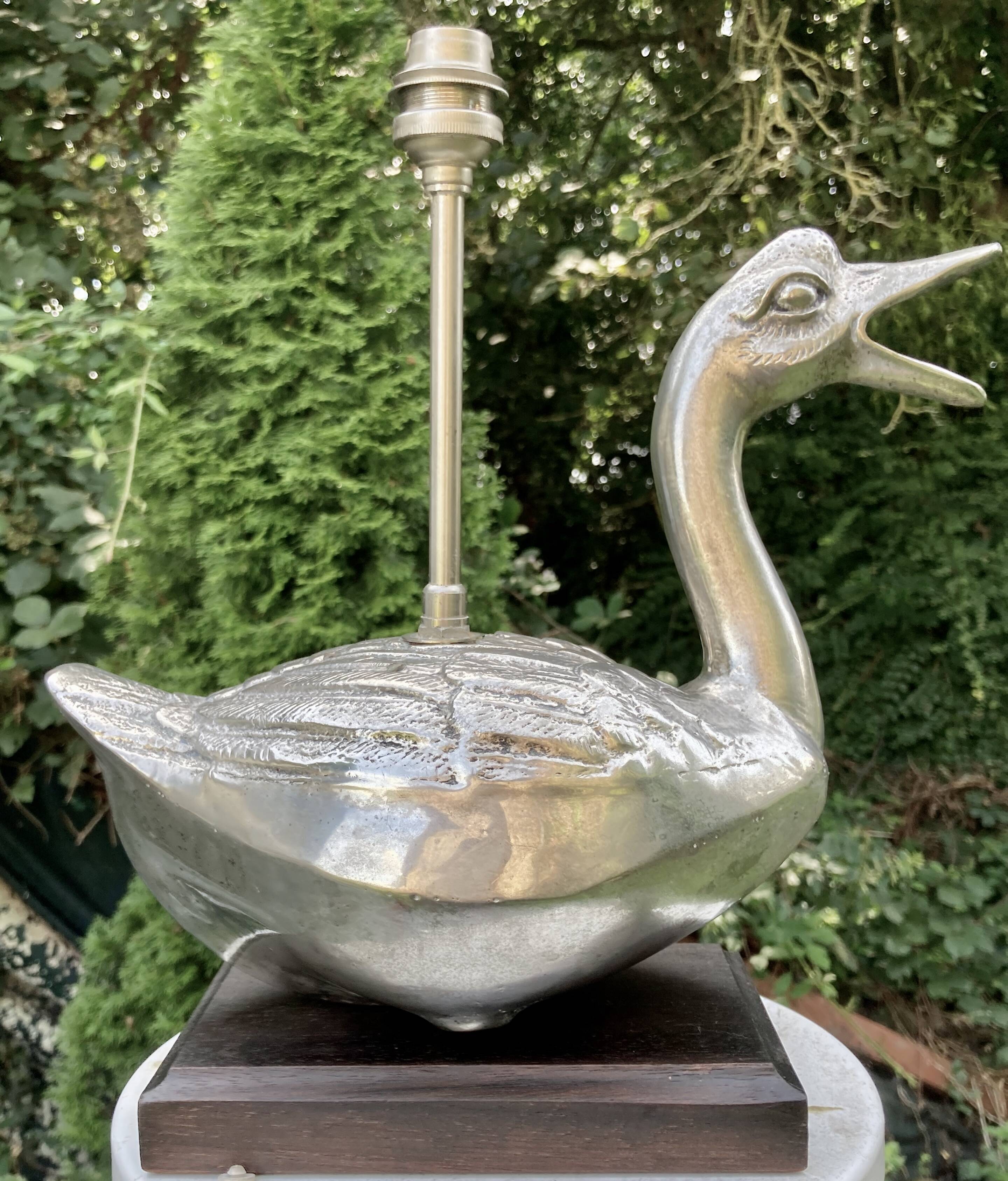 Old vintage lamp representing a duck in silver metal with wooden base