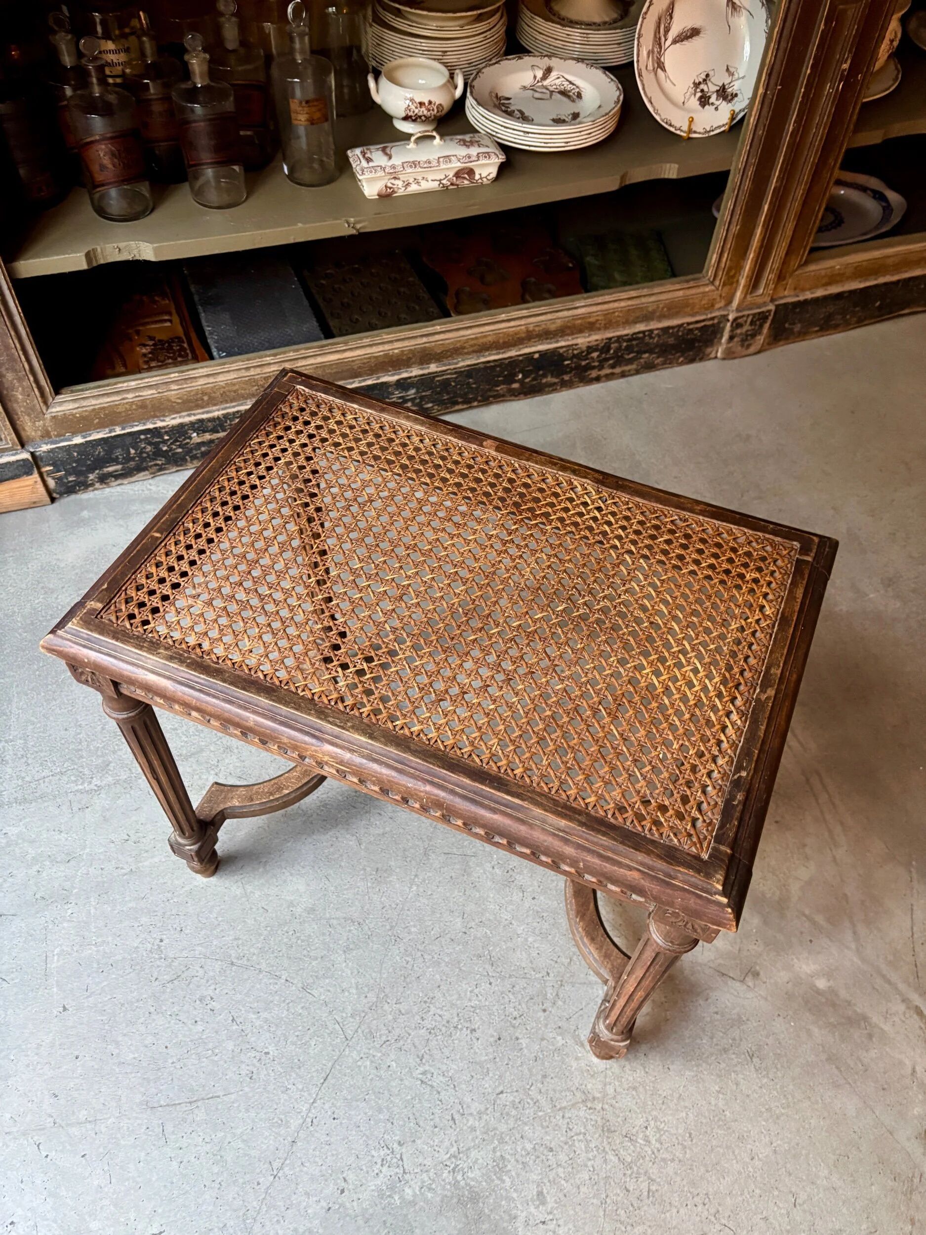 Stool, small wooden piano bench with carved details and caning.