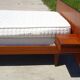 Vintage bed in teak with integrated bedside table.