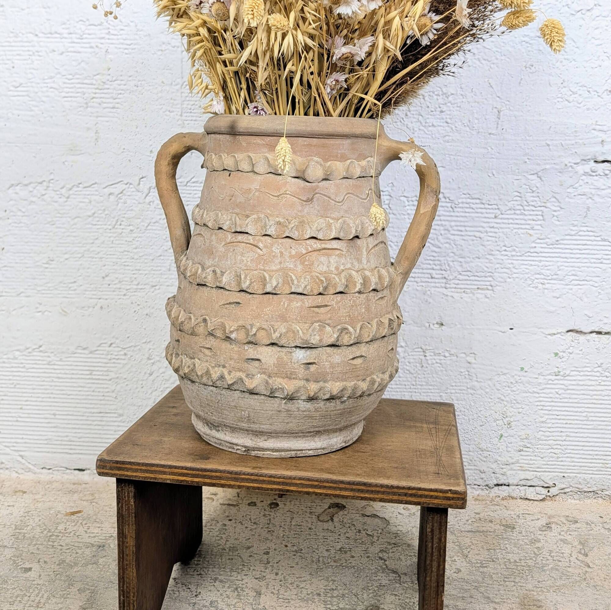 Terracotta jar with two handles, decorated with garlands.