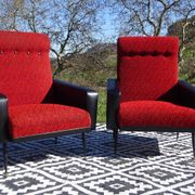 Pair of vintage armchairs in black faux leather and red fabric.