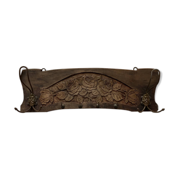 Wall-mounted coat rack in carved wood with rose decoration.