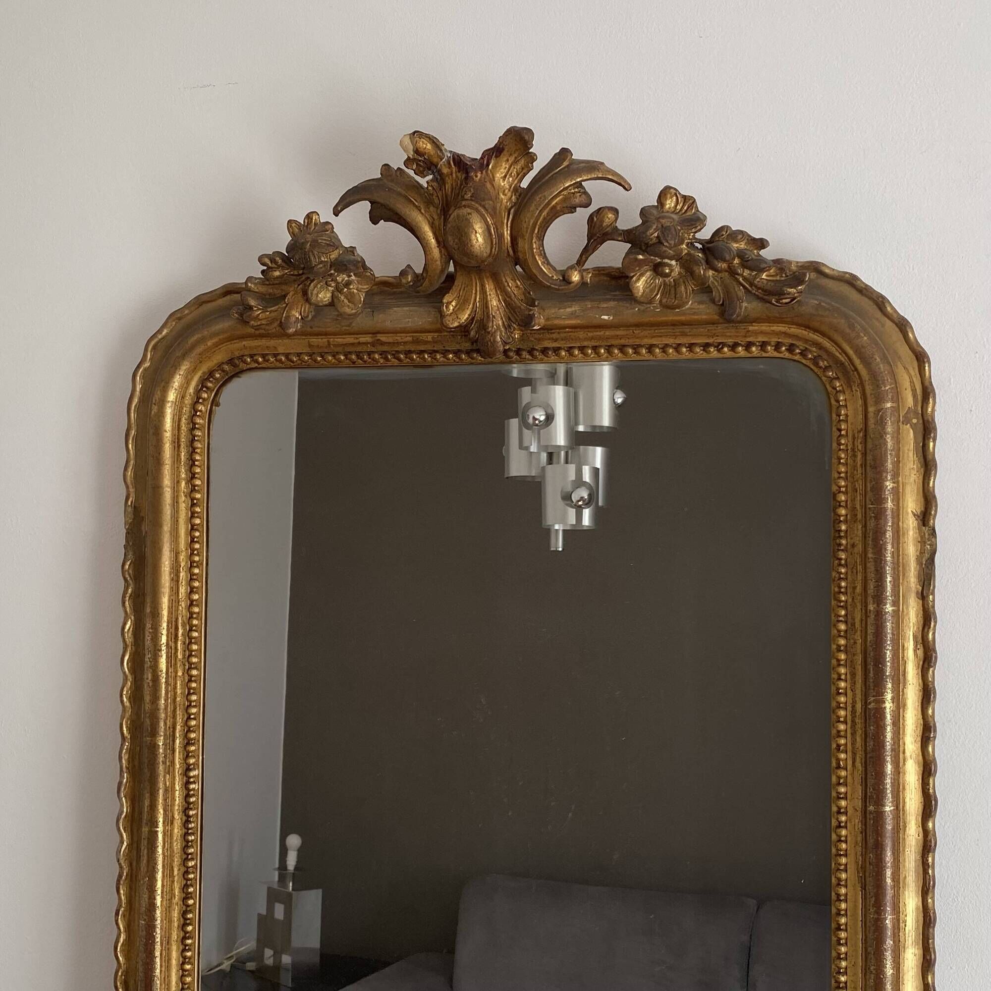 Golden mirror from the late 19th century with a decorated pediment. 130x74.