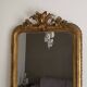 Golden mirror from the late 19th century with a decorated pediment. 130x74.