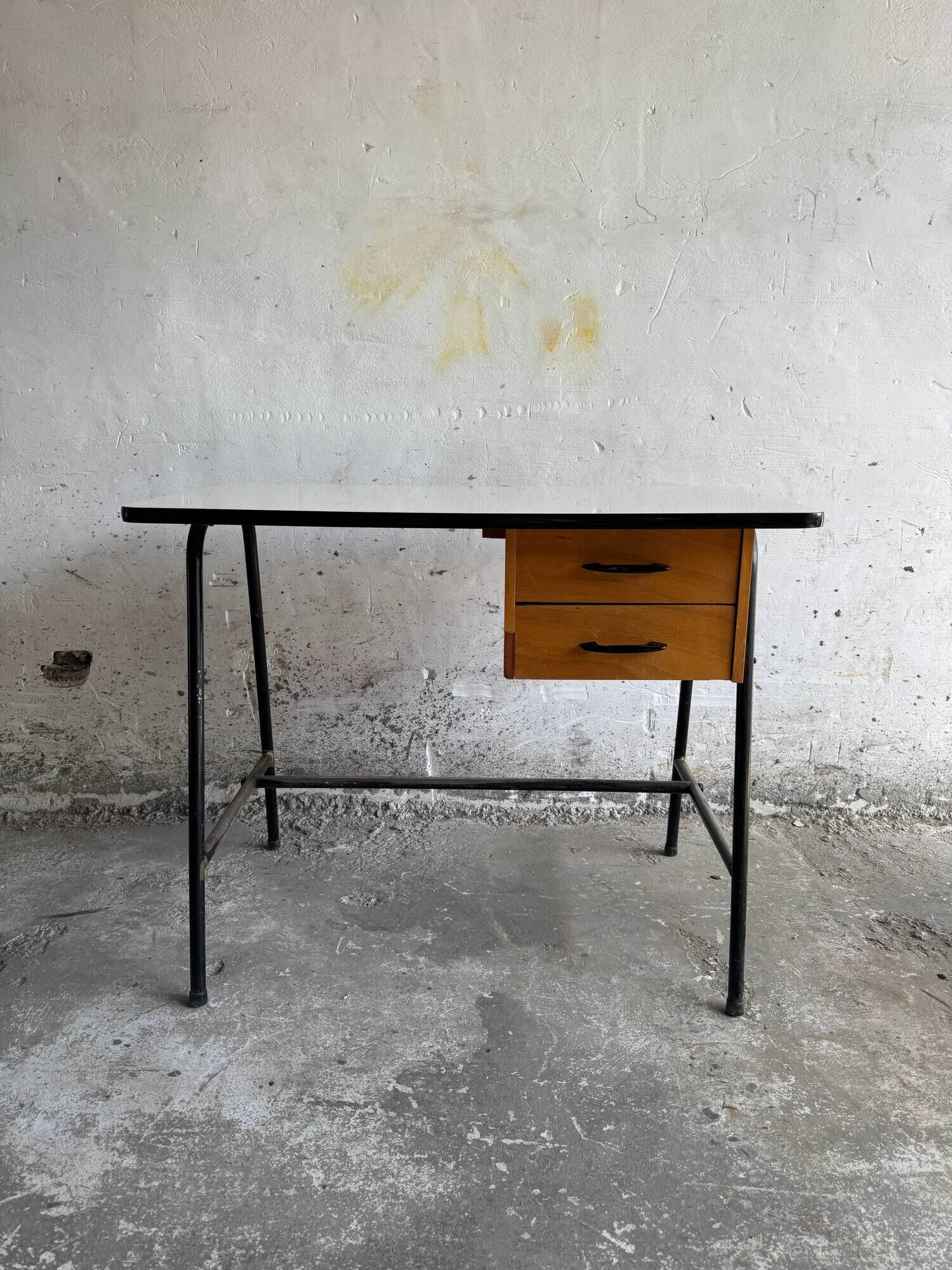 Black metal and wood mid-century industrial desk with laminated top and two drawers