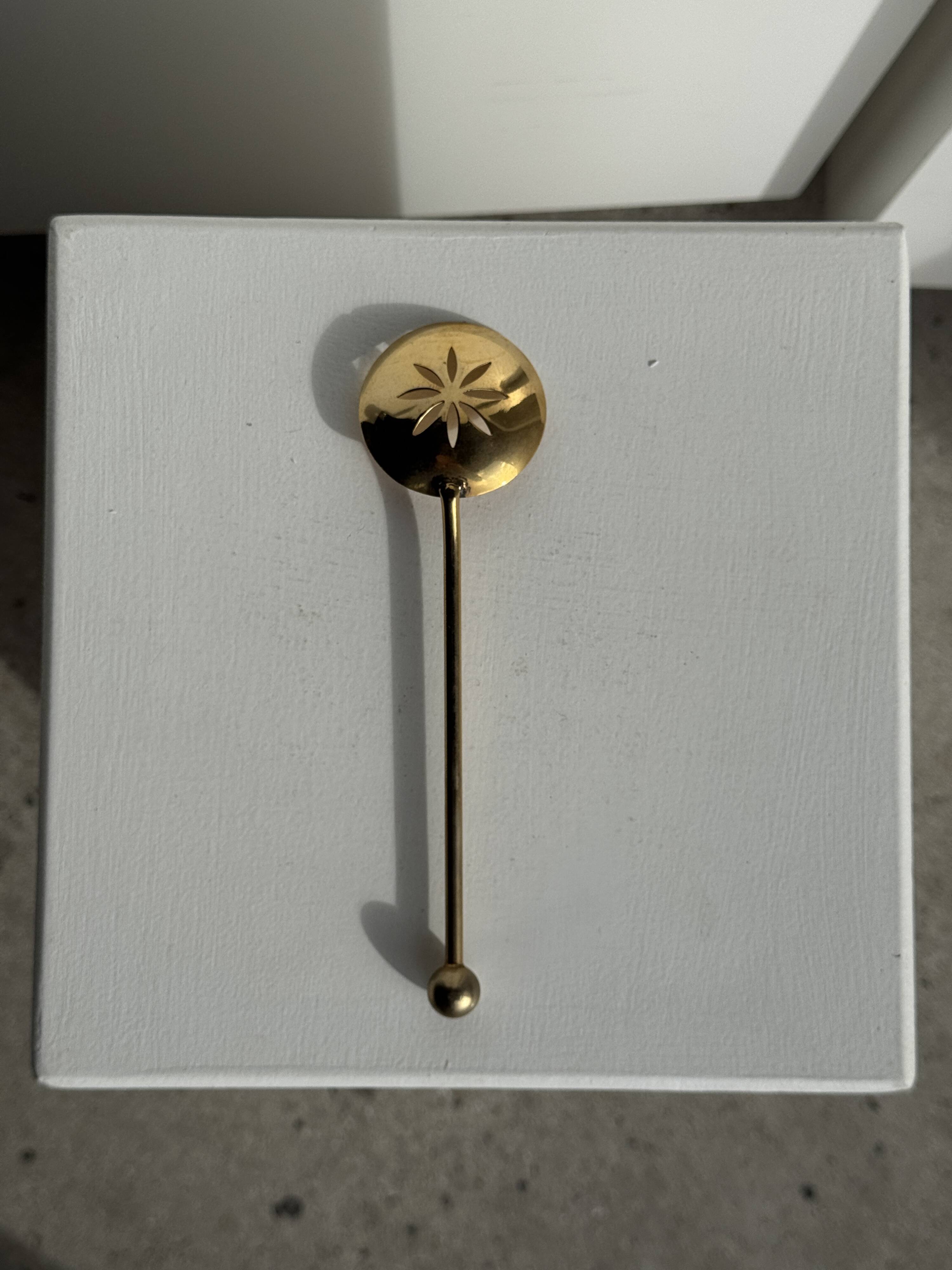 Small golden glass ice bucket with diamond point design and its scoop.