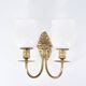 Three brass and opaque glass wall lights, 1950s.