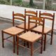 4 dining or kitchen chairs made of solid wood with rush seats.