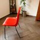 Pair of red plastic chairs with metal frame