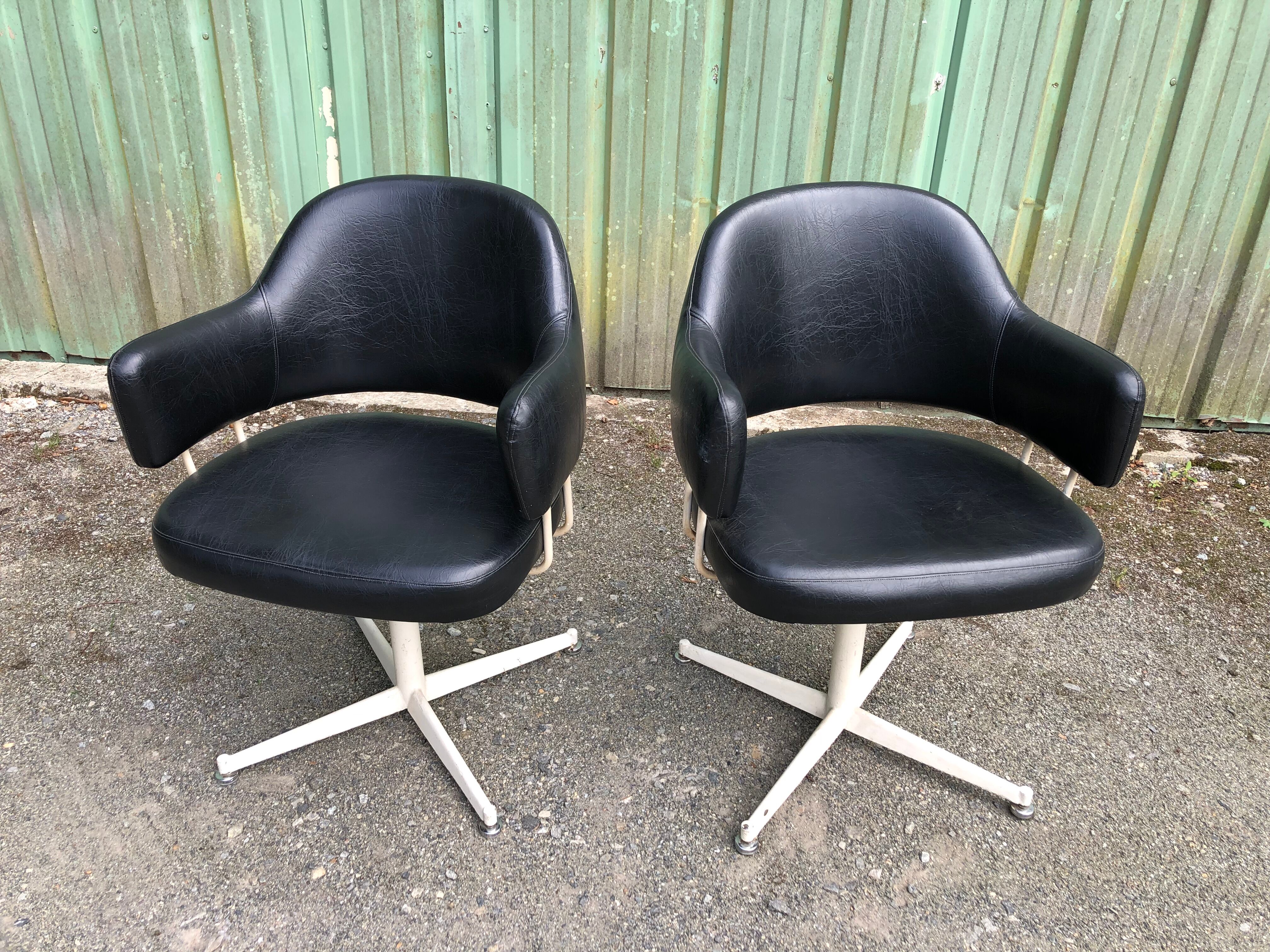 Pair of vintage armchairs in black skai with metal legs.