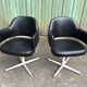 Pair of vintage armchairs in black skai with metal legs.
