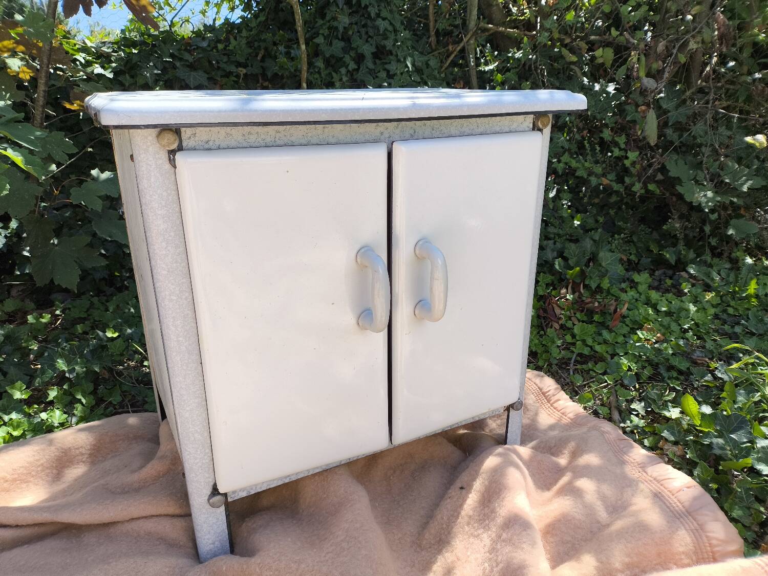 Small white and speckled gray industrial style enameled piece of furniture