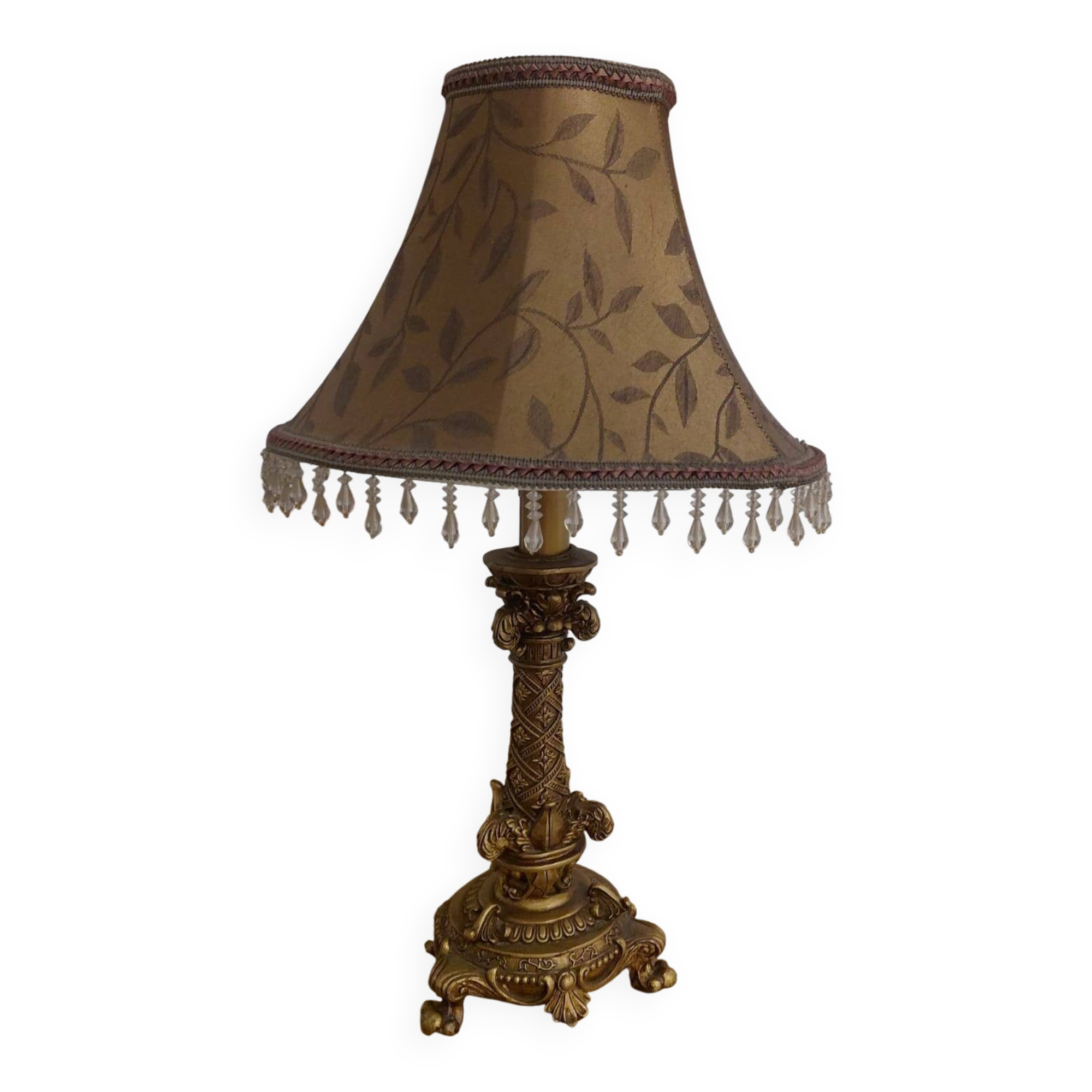 Golden baroque-style table lamp with a shade adorned with pendants.