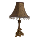 Golden baroque-style table lamp with a shade adorned with pendants.