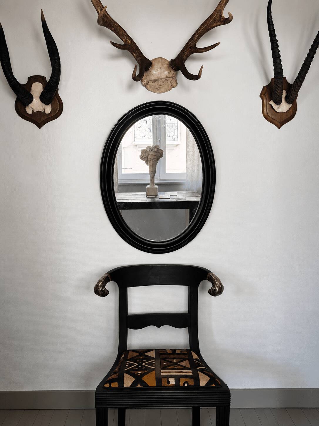 Antique oval mirror in patinated black wood