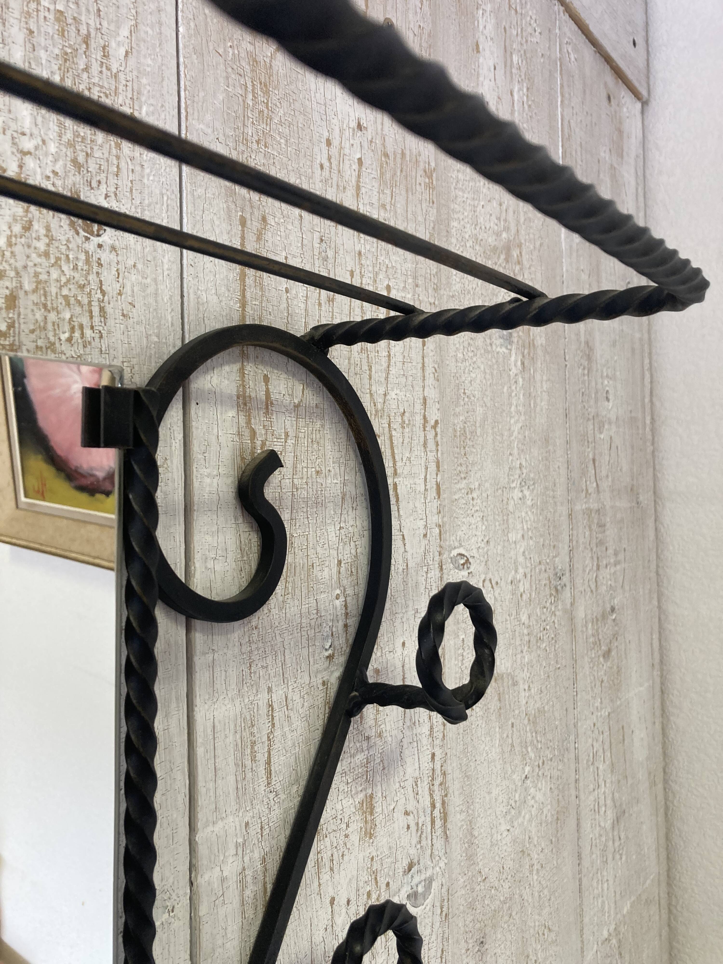 Wall-mounted coat rack with its mirror.