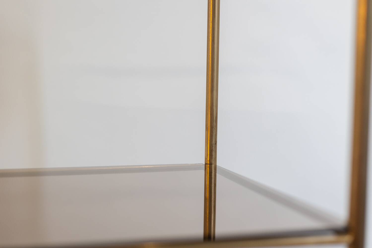 Free-standing shelf in gilded brass with smoked glass shelves. 1970s.