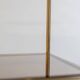 Free-standing shelf in gilded brass with smoked glass shelves. 1970s.