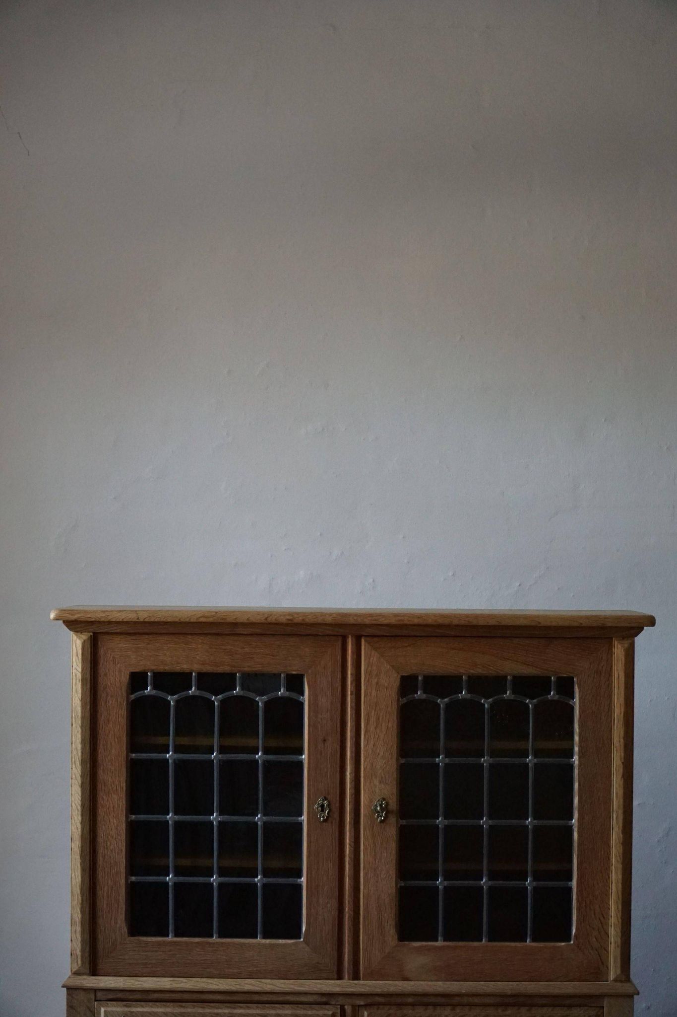 20th-century mid-century solid oak sideboard with glass front, by a Danish cabinetmaker.